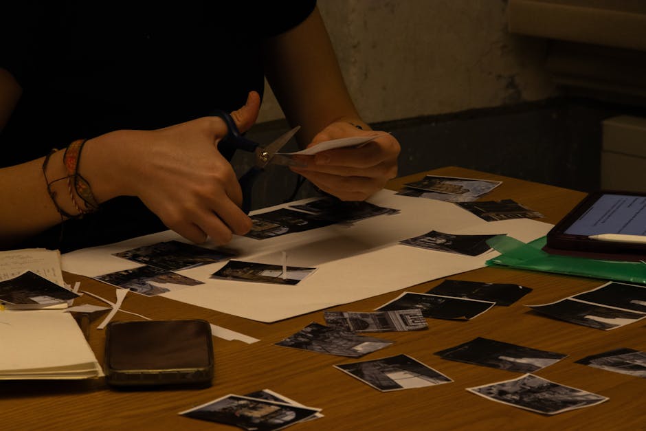 A person cutting photos for a collage project in a creative workshop setting.